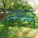 pair of green english garden benches with metal cane seats