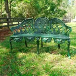 pair of green english garden benches with metal cane seats