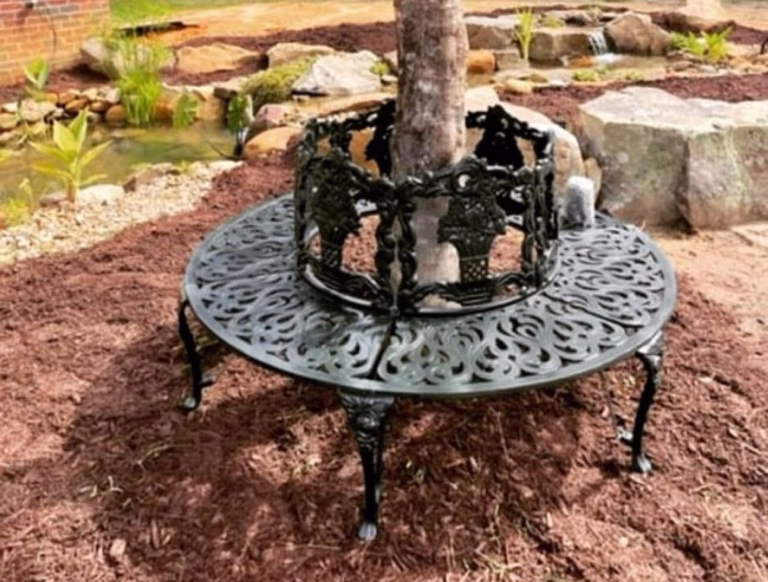 Customer Showcase Customer photo of a Victorian circular cast aluminum tree bench from The Kings Bay around a tree in a landscaped garden